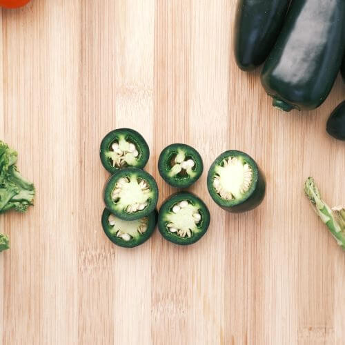 slices of jalapeno on a wooden background