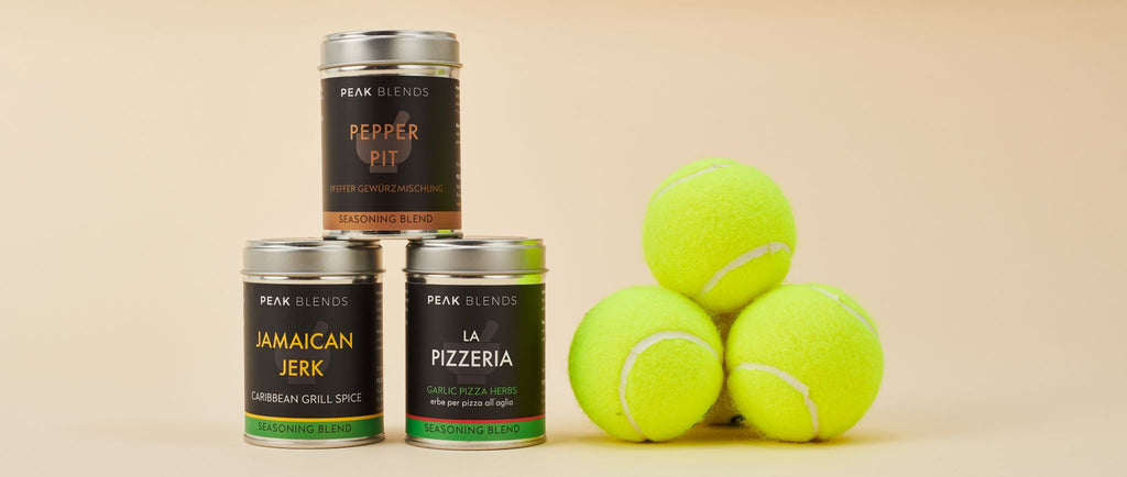 tins of pepper pit, jamaican jerk and la pizzeria stacked next to three tennis balls