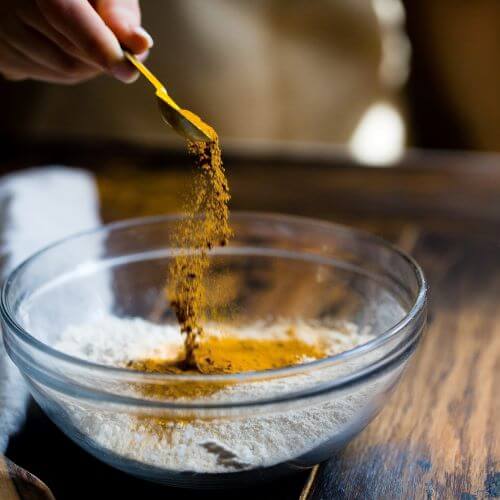 turmeric being poured into a bowl